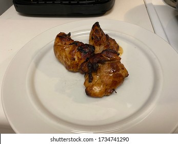 Marinaded Chicken Thighs Cooked In An Air Fryer On A White Plate