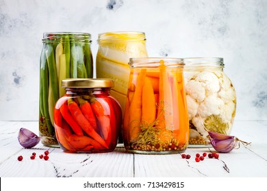 Marinated pickles variety preserving jars. Homemade green beans, squash, cauliflower, carrots, red chili peppers pickles. Fermented food. 