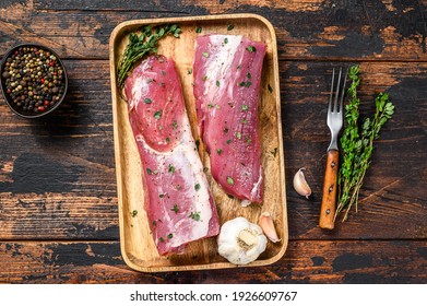 Marinated pork tenderloin meat steak with thyme. Dark wooden background. Top view. - Shutterstock ID 1926609767