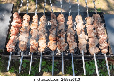 Marinated shashlik preparing on a barbecue grill over charcoal. Shashlik or Shish kebab popular in Eastern Europe.