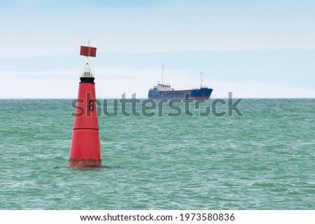 Marine buoy in the fairway. Navigational signs. Escorting the ship to the port.