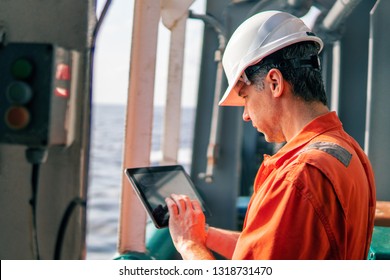 Marine chief officer or captain on deck of vessel or ship watching digital tablet. Internet and home connection at sea.