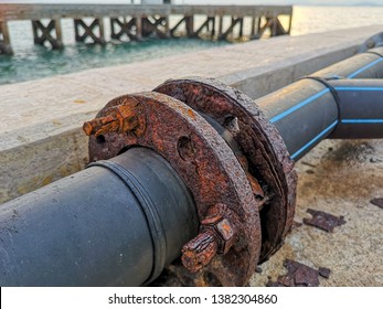 Marine corrosion in the form of general attack on carbon steel flanges or metal equipment on pier. Area most affected is wet and dry zones. Severe corrosion was evidenced by corrosion product layers. - Shutterstock ID 1382304860