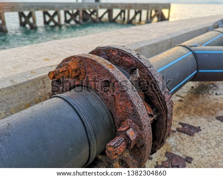 Marine corrosion in the form of general attack on carbon steel flanges or metal equipment on pier. Area most affected is wet and dry zones. Severe corrosion was evidenced by corrosion product layers.