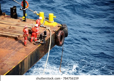 Marine crews working on mooring ropes on cargo barge at offshore - Shutterstock ID 784756159