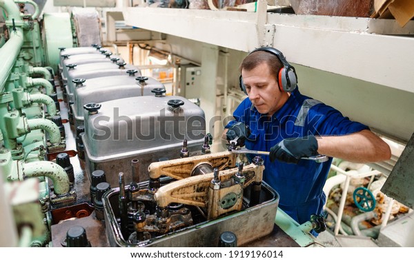 Marine\
engineer officer reparing vessel engines and propulsion in engine\
control room ECR. Ship onboard\
maintenance