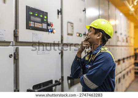 Marine engineer operating the generator control panel inside the engine room, monitoring onboard power production on a commercial vessel.