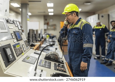 Marine engineer operating main engine control panel inside the ship’s engine control room, managing propulsion systems of a commercial cargo vessel.