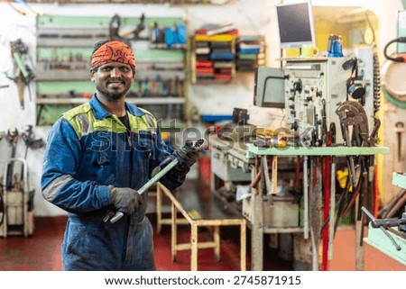 Marine engineer working inside the engine room of a commercial cargo vessel, surrounded by ship machinery and industrial equipment.