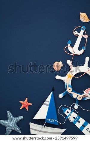 Marine flat lay featuring anchor, seashells, ship wheel, starfish, sailboat, and lighthouse decorations on navy blue background