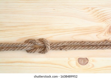 Marine Knot Used In Yachting, Square Knot. Nautical Knot On Wooden Background.