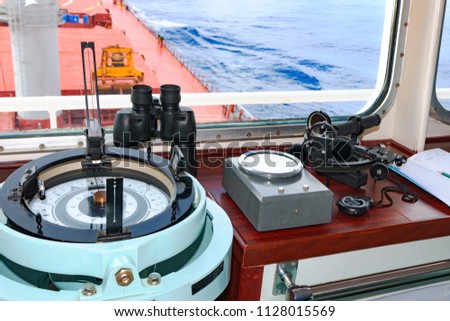 Marine navigation instruments on the bridge of ship at sea: sextant, chronometer, navigation map and binoculars