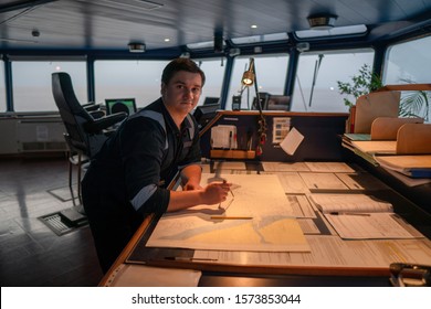 Marine Navigational Officer During Navigational Watch On Bridge . He Does Chart Correction Of Nautical Maps And Publications. Work At Sea