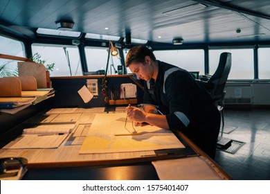 Marine Navigational Officer During Navigational Watch On Bridge . He Does Chart Correction Of Nautical Maps And Publications. Work At Sea