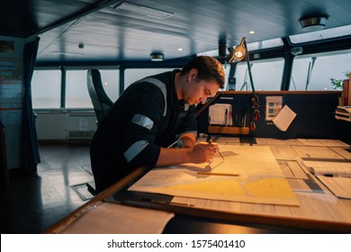 Marine Navigational Officer During Navigational Watch On Bridge . He Does Chart Correction Of Nautical Maps And Publications. Work At Sea