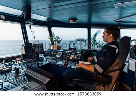 Marine navigational officer during navigational watch on Bridge . Work at sea