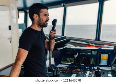 Marine Navigational Officer Is Reporting By VHF Radio During Navigation Watch. Bridge GMDSS Watch