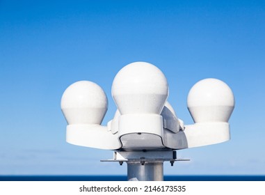 Marine satellite installation of several domed navigation antennas against the sky.