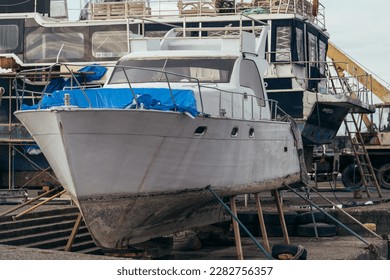 Marine sea boat under repair and maintenance on pier - Shutterstock ID 2282756357