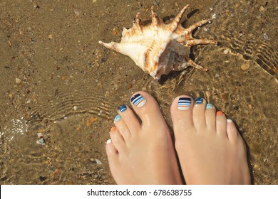 Marine Striped Multicolored Pedicure On Female Nails On Summer Sea Closeup.