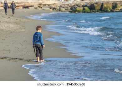 Marinella di Sarzana, La Spezia Italia - March 28 2021: clild playung alone on the shoreline.