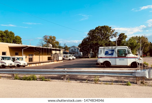 Marinette,WI/\
U.S.A.-Aug1-2019:Many post office cars are waiting in front of the\
post office. At the time of\
sunset