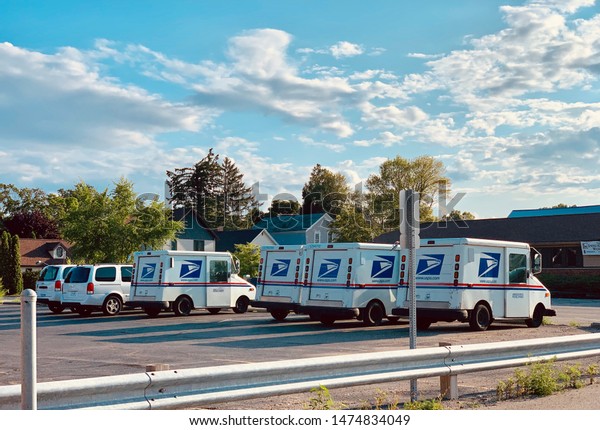 Marinette,WI/
U.S.A.-Aug1-2019:Many post office cars are waiting in front of the
post office. At the time of
sunset
