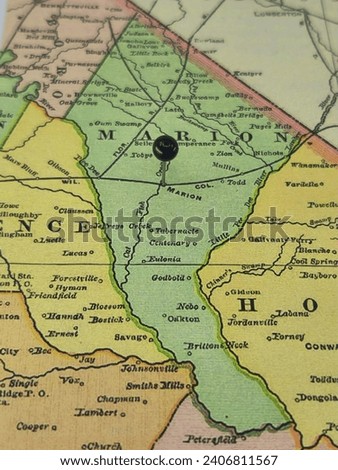 Marion County, South Carolina marked by a black tack on a colorful vintage map. The county seat is located in the city of Marion, SC.