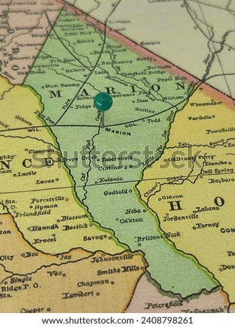 Marion County, South Carolina marked by a green tack on a colorful vintage map. The county seat is located in the city of Marion, SC.