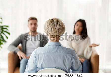 Marital Therapy. Professional Psychologist Sitting Back To Camera During Appointment With Unhappy Couple In Office. Rear View, Selective Focus