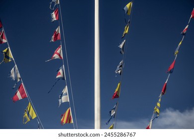 Maritime flags against blue sky. Nautical flags fluttering in the wind. Colorful signal flags