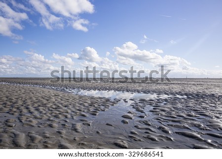 Maritime mudflat landscape with reflection of clouds in low tide water, Waddenzee, Friesland, The Netherlands