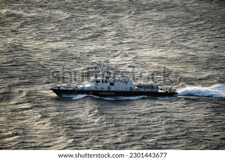 Maritime police ship vigorously cutting through the waves
The words on the ship are 