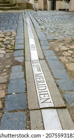 marker embedded in street pavement for the 15th meridian (15th meridian in French, japanese and italian translation)east longitude in the Czech town of jindrichuv Hradec.