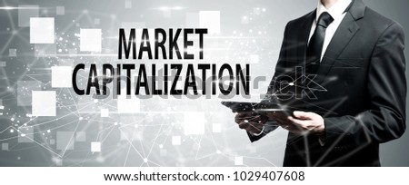 Market Capitalization with man holding a tablet computer