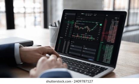 Market growth, profit, trading. Businessman, trader sits at workplace desk with laptop, makes analysis of long-term investments, check stock, cryptocurrency statistics data shown in graphs and charts - Powered by Shutterstock