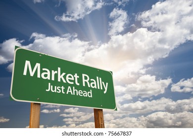 Market Rally Green Road Sign With Dramatic Clouds, Sun Rays And Sky.