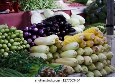 Market Stall Selling Fresh Produce. Aubergine/eggplants, Corns, Morning Glory, And Green Vegetables On The Shelf. Wet Market In Asia.