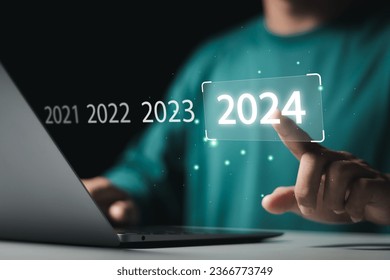Market trend for 2024. Businessman touching virtual number 2024 for Merry christmas and happy new year concept. End of the old year and start of new business in 2024.