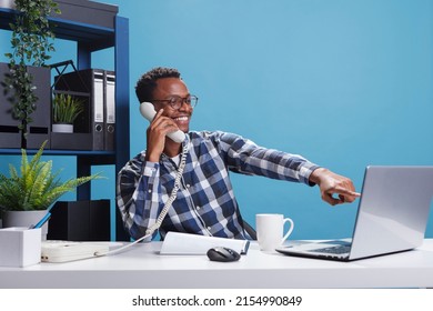 Marketing Company Happy Joyful African American Office Worker On Landline Call With Accountant Talking About Expenses Report. Cheerful Smiling Manager On Telephone Conversation With Team Leader