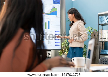 Marketing graduate intern leads first business meeting, explains company's sales rankings and charts. The girl is facing the interactive whiteboard, she is stressed about speaking in front of workmate Stock photo © 