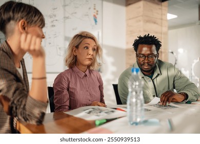 Marketing professionals analyze print media layouts during a collaborative strategy session in a modern office, fostering teamwork and innovative solutions - Powered by Shutterstock