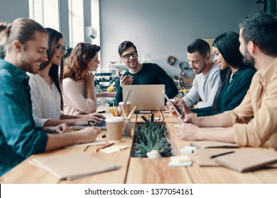 Marketing team. Group of young modern people in smart casual wear discussing something while working in the creative office               - Shutterstock ID 1377054161