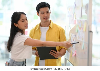 Marketing Team Officers Planning Their Marketing Campaign And Strategy, Looking The Details On The Whiteboard Or Flip Chart.