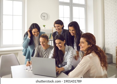 Marketing Team Using Laptop Computer All Together. Group Of Happy Positive Smiling Young Women Meeting In Office, Working On Project, Sharing Ideas And Communicating With Business Partners Online