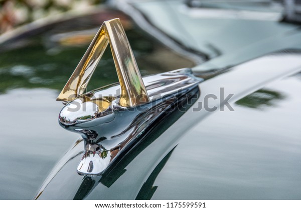 Markham, Ontario / Canada – September 9, 2018: A\
closeup of the shiny chrome and gold hood ornament on a vintage\
classic black 1951 Hudson\
Hornet.