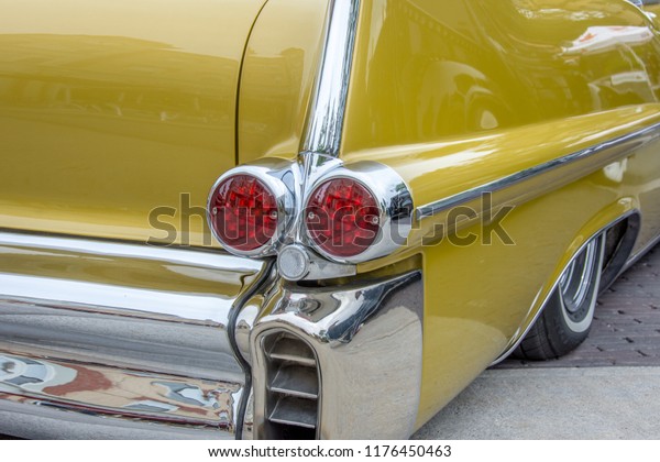 Markham,\
Ontario / Canada – September 9, 2018: Classic profile view of a\
beautiful golden yellow 1957 Cadillac Coupe, with the tail light\
housing, chrome bumper, and wheel cover.\
