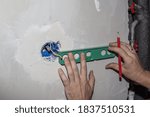 marking an additional socket of an electrical outlet on a cement wall.