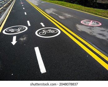 Marking bike path. Track for cyclists with directions. Bike path and walkway for walkers. Dividing line for bicycles and pedestrians. Permission and caution. Signs drawn on the pavement.