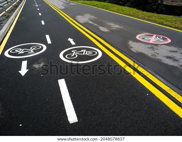 Marking bike path. Track for cyclists with
directions. Bike path and walkway for walkers. Dividing line for
bicycles and pedestrians. Permission and caution. Signs drawn on
the pavement.